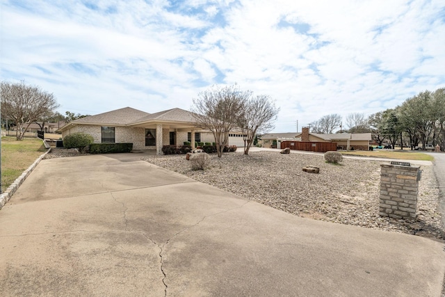 view of front of home featuring a garage, concrete driveway, and brick siding