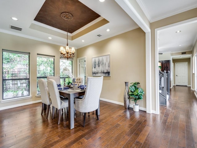 dining space featuring dark wood-type flooring, a raised ceiling, visible vents, and ornamental molding