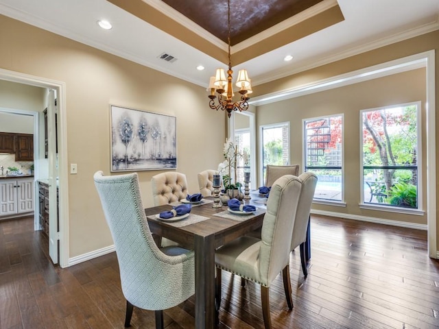 dining area with visible vents, a raised ceiling, dark wood finished floors, ornamental molding, and a notable chandelier