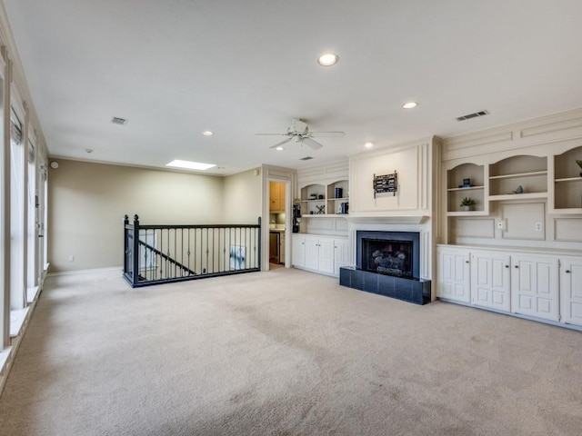 unfurnished living room with visible vents, light colored carpet, built in shelves, a fireplace, and recessed lighting