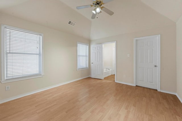 unfurnished bedroom with lofted ceiling, light wood-style floors, multiple windows, and visible vents