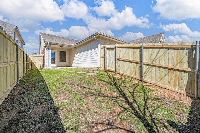 rear view of house with a fenced backyard