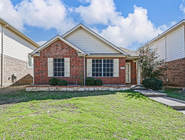 ranch-style home with a front yard and brick siding