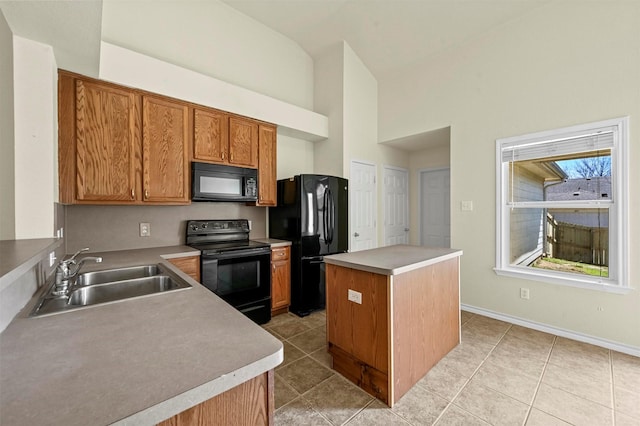 kitchen featuring a kitchen island, light tile patterned flooring, a sink, and black appliances