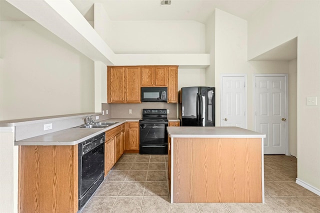 kitchen featuring a center island, light countertops, black appliances, a sink, and light tile patterned flooring