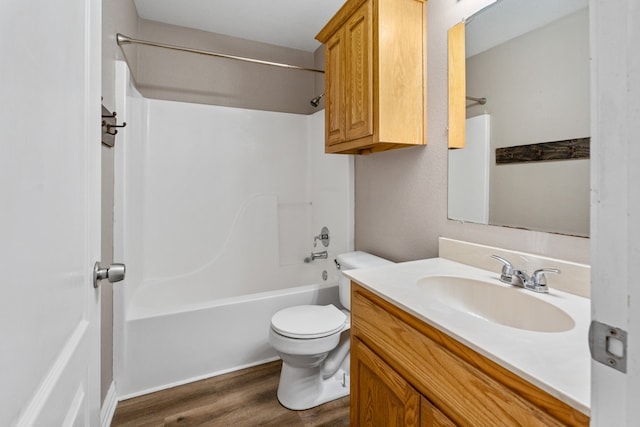 bathroom featuring toilet, shower / washtub combination, wood finished floors, and vanity