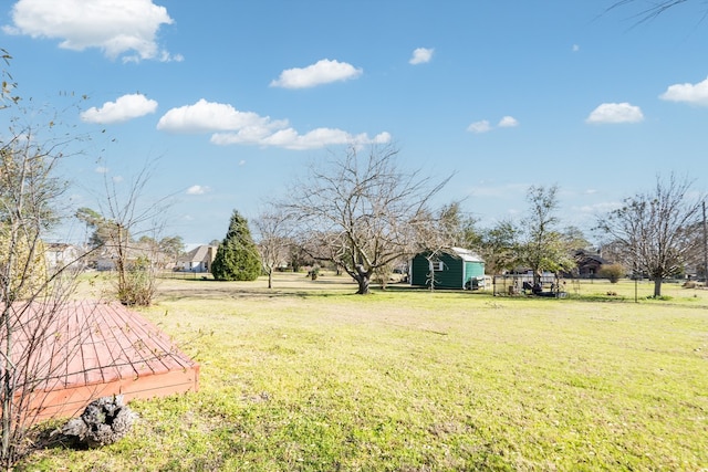 view of yard with an outdoor structure, a shed, and fence