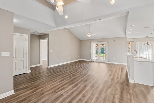 unfurnished living room with french doors, vaulted ceiling, wood finished floors, baseboards, and ceiling fan with notable chandelier