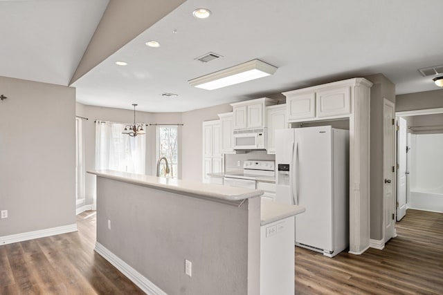 kitchen featuring white appliances, a center island with sink, visible vents, white cabinets, and light countertops