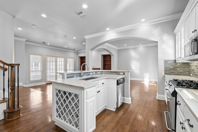 kitchen with visible vents, dark wood-type flooring, light stone countertops, stainless steel appliances, and a sink