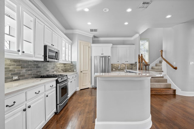 kitchen with dark wood-style floors, stainless steel appliances, visible vents, and white cabinetry