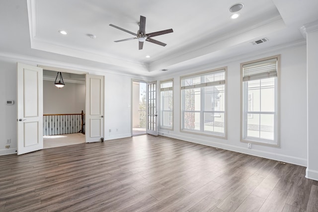 unfurnished room featuring dark wood-style floors, baseboards, ornamental molding, and a raised ceiling