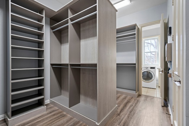 spacious closet featuring washer / clothes dryer and wood finished floors