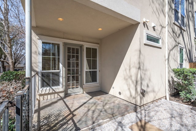 property entrance with a patio and stucco siding