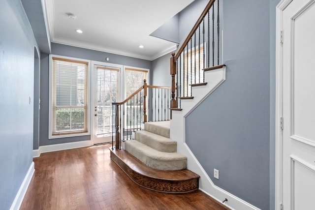 foyer entrance featuring dark wood-style floors, crown molding, baseboards, and stairs