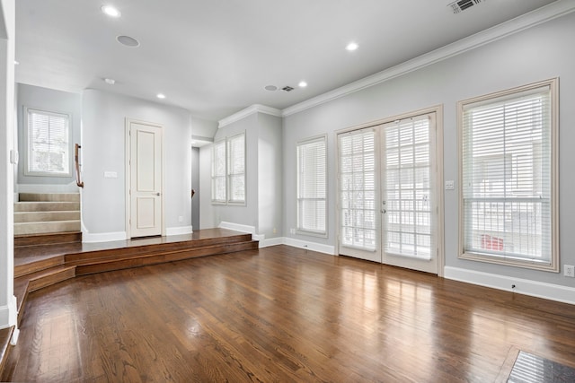 empty room featuring stairway, wood finished floors, and a healthy amount of sunlight