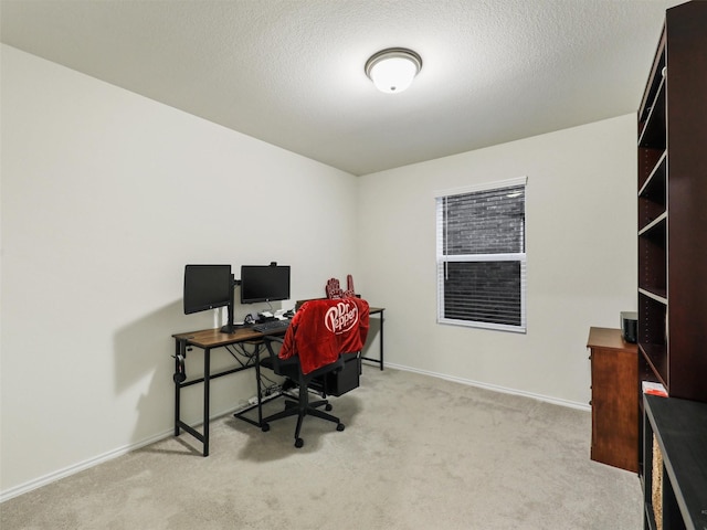 carpeted office featuring baseboards and a textured ceiling