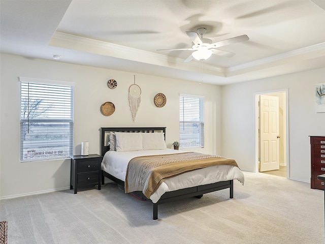 bedroom with baseboards, a raised ceiling, and light colored carpet