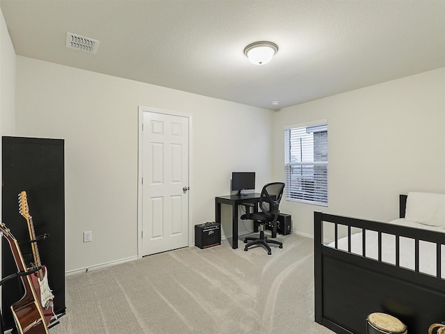 carpeted home office with visible vents, baseboards, and a textured ceiling