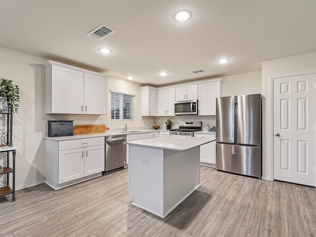 kitchen featuring light wood finished floors, visible vents, stainless steel appliances, and a sink