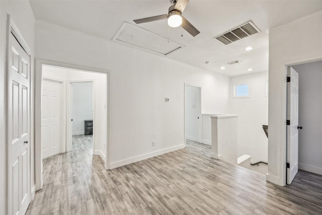 empty room with recessed lighting, visible vents, attic access, wood finished floors, and baseboards