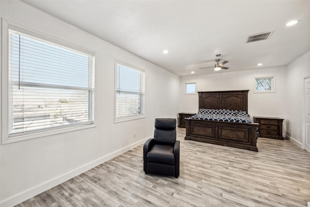 bedroom featuring light wood-type flooring, visible vents, baseboards, and multiple windows