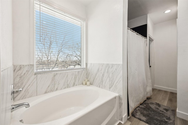 full bathroom featuring a garden tub and wood finished floors