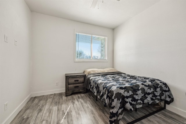 bedroom featuring a ceiling fan, baseboards, and wood finished floors