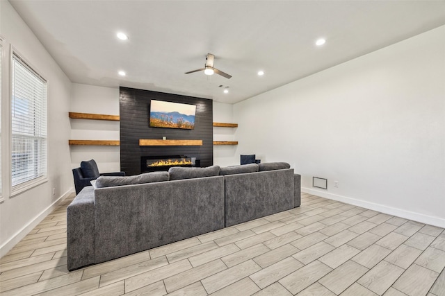 living room with recessed lighting, wood finish floors, a fireplace, a ceiling fan, and baseboards