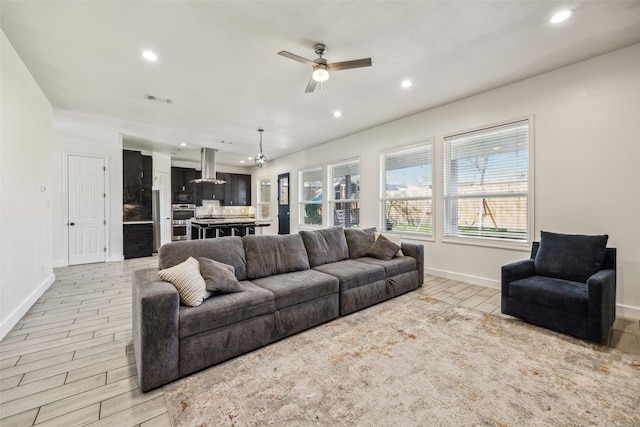 living room with recessed lighting, visible vents, light wood-style floors, ceiling fan, and baseboards