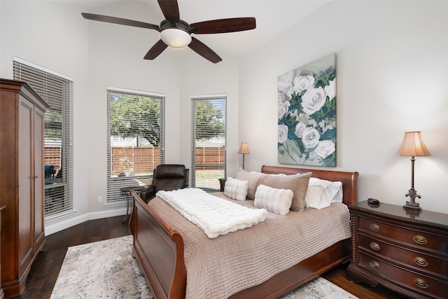 bedroom with dark wood-type flooring, ceiling fan, and baseboards