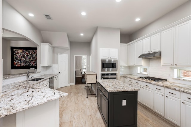 kitchen featuring stainless steel appliances, white cabinets, a sink, and under cabinet range hood