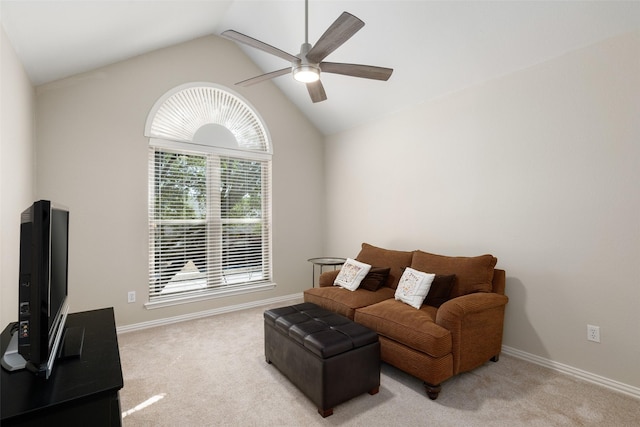 living room with lofted ceiling, baseboards, a ceiling fan, and light colored carpet