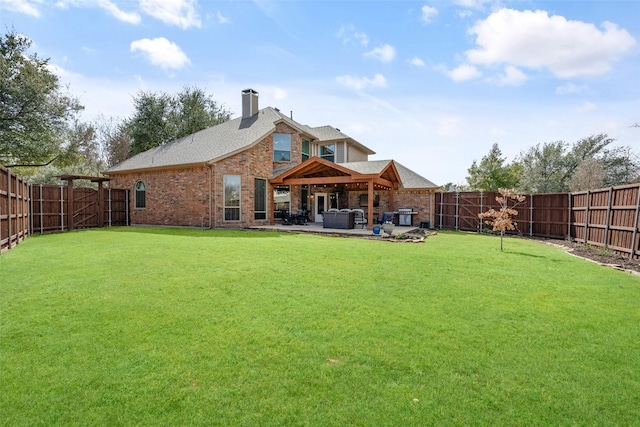 rear view of property featuring brick siding, a patio, and a fenced backyard