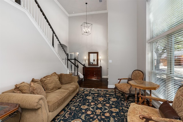 living room featuring baseboards, stairway, wood finished floors, a high ceiling, and crown molding