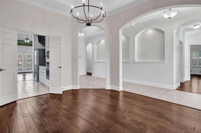 unfurnished dining area with crown molding, baseboards, wood finished floors, and a healthy amount of sunlight