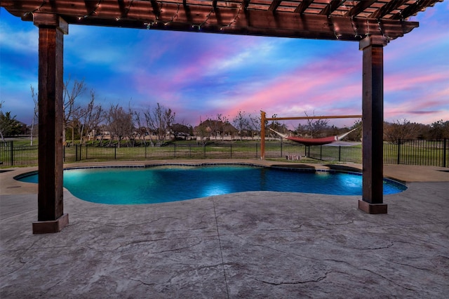 pool at dusk featuring fence, a yard, a fenced in pool, a pergola, and a patio area