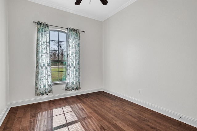 empty room featuring baseboards, ornamental molding, dark wood finished floors, and a ceiling fan