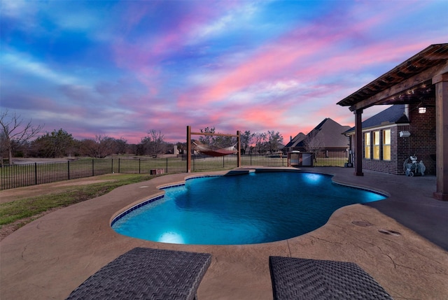 pool at dusk featuring a patio, a fenced backyard, and a fenced in pool