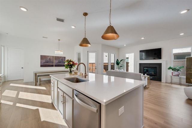 kitchen featuring a sink, light wood-type flooring, stainless steel dishwasher, and recessed lighting