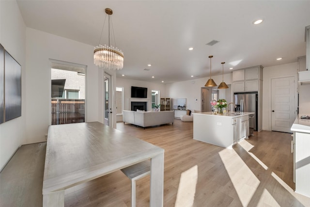 kitchen featuring recessed lighting, light countertops, a fireplace, and light wood-style flooring