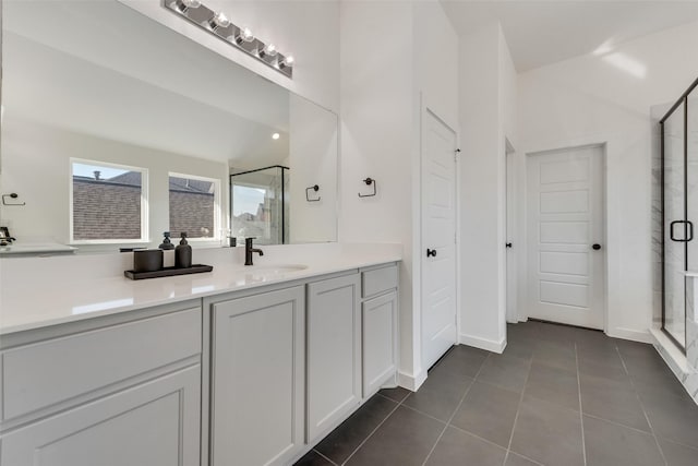 full bathroom featuring vaulted ceiling, a shower stall, vanity, baseboards, and tile patterned floors