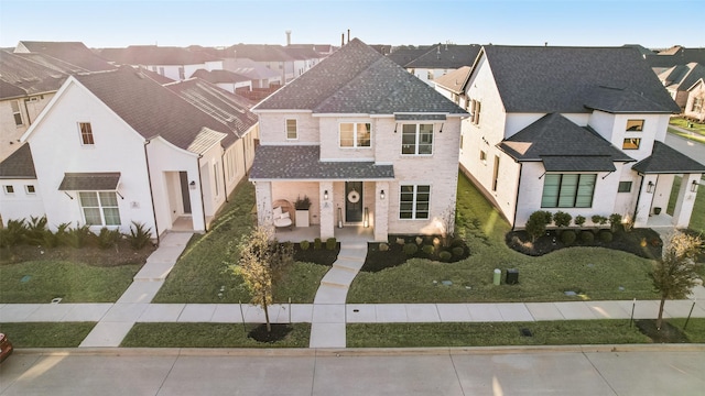 view of front of house featuring a shingled roof, a residential view, and brick siding