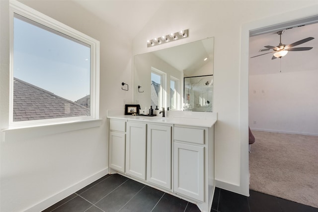 bathroom featuring baseboards, a shower, lofted ceiling, tile patterned flooring, and vanity