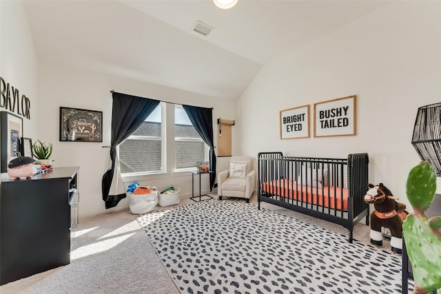 bedroom featuring a crib, carpet floors, visible vents, and vaulted ceiling