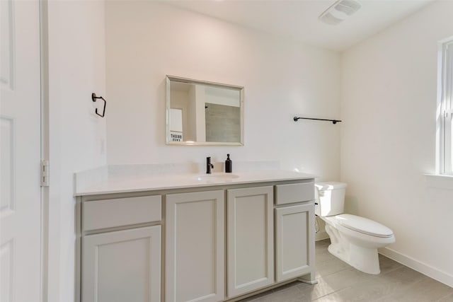 bathroom with toilet, baseboards, and vanity