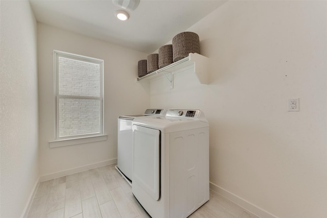 washroom featuring laundry area, baseboards, and washing machine and clothes dryer