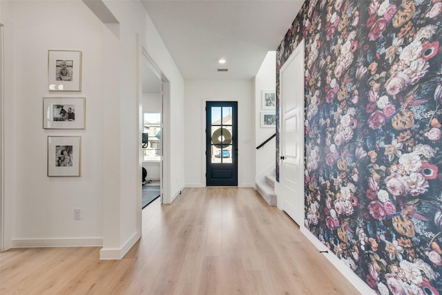 entrance foyer with baseboards, stairway, and light wood-style floors