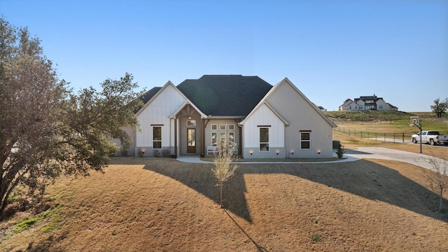 modern farmhouse style home with fence and board and batten siding