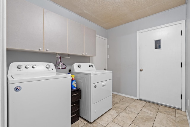 clothes washing area with cabinet space, a textured ceiling, and independent washer and dryer